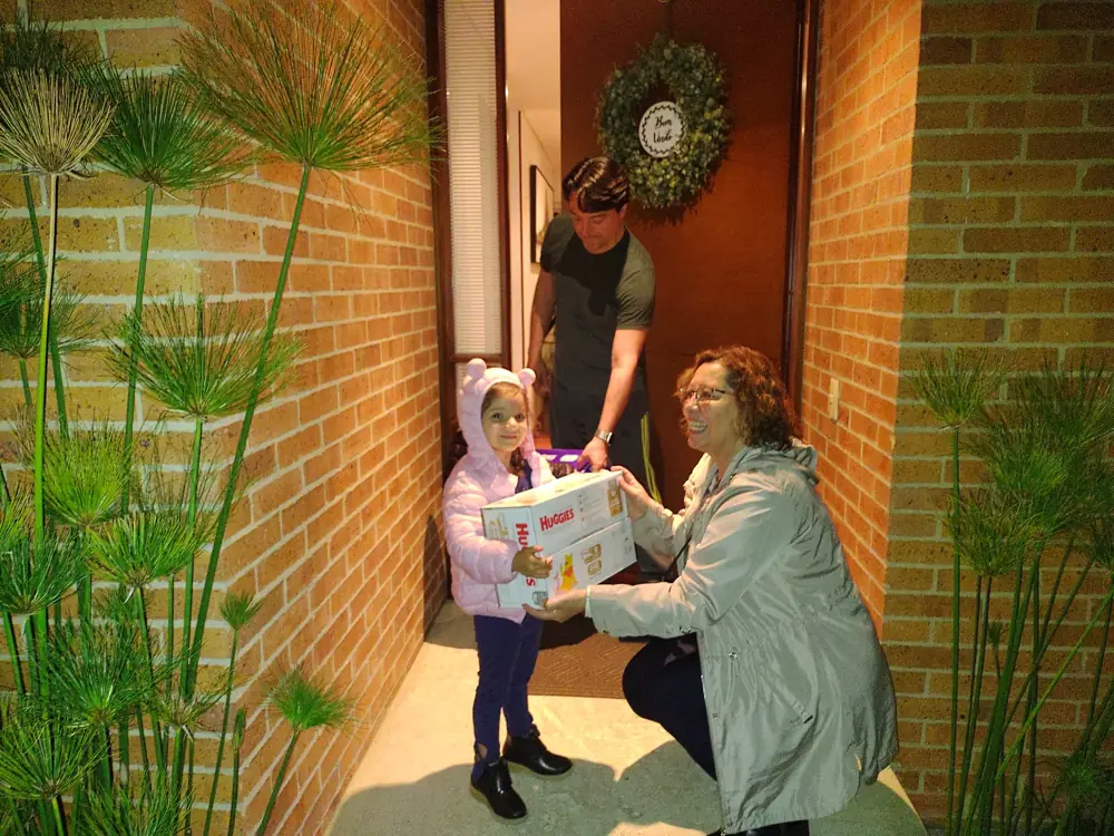Una voluntaria entrega un regalo en la entrada de la sede
