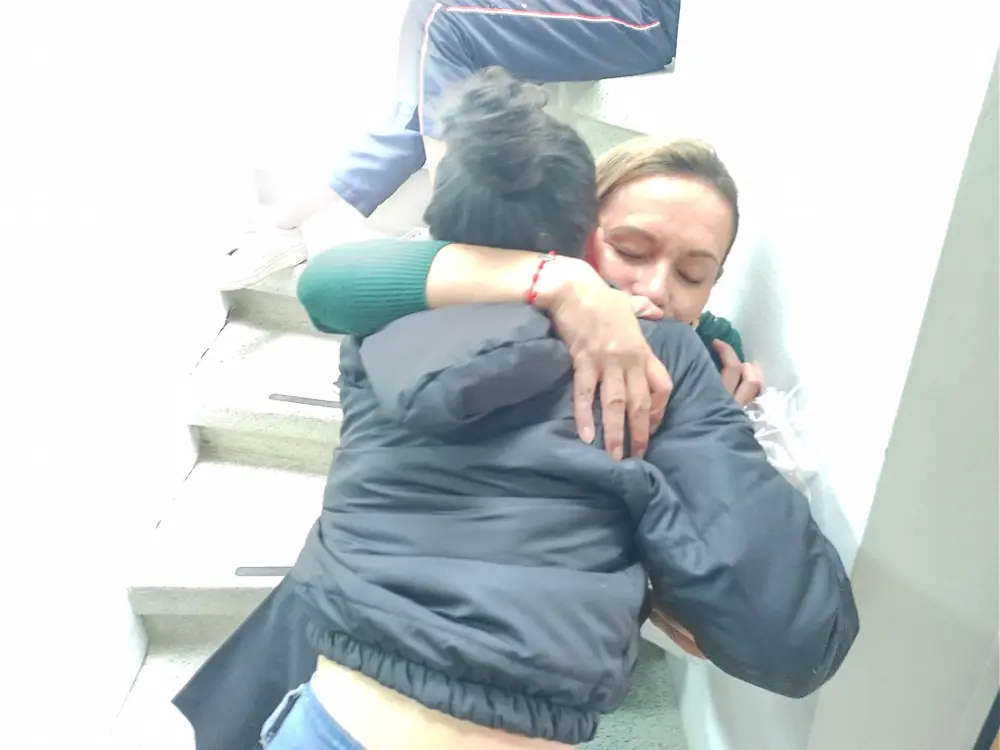 Abrazo entre una mamá y una voluntaria