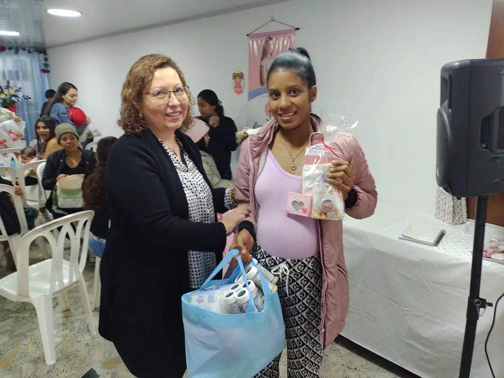 Una voluntaria entrega un kit de nacimiento a una mamá gestante