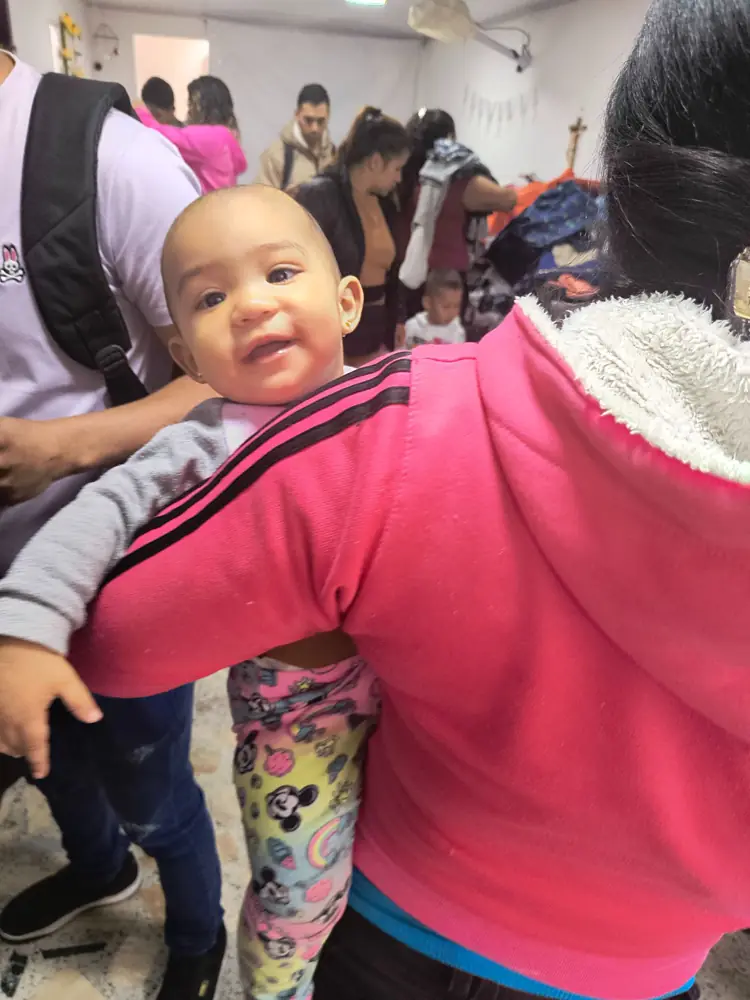 Bebé sonriente en brazos de su mamá