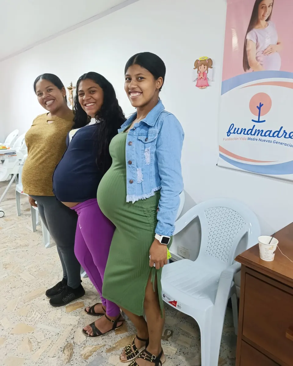 Tres mamás gestantes sonríen juntas en la sede de Fundmadre